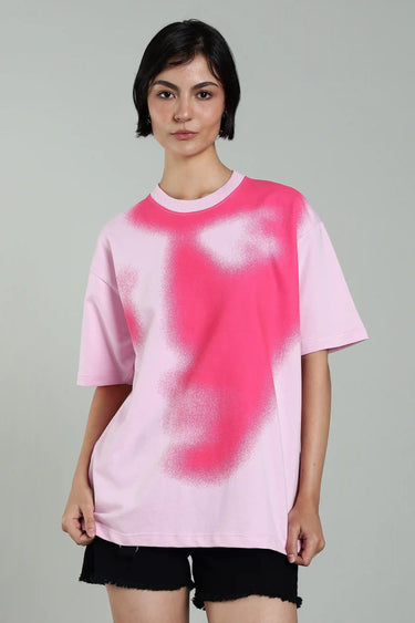 front profile of a woman wearing oversized pink abstract face t-shirt.