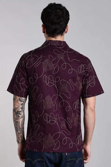 back view of a man wearing purple embroidery shirt
