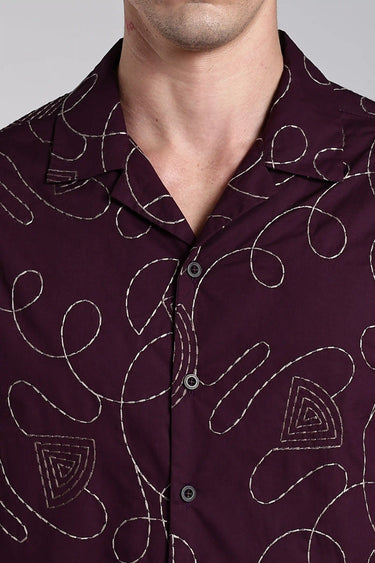 close-up view of a man wearing purple embroidery shirt
