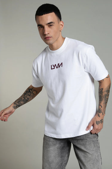 A man wearing the oversized, unisex white phoenix t-shirt with the LYVN logo on the front, holding a basketball against a plain background