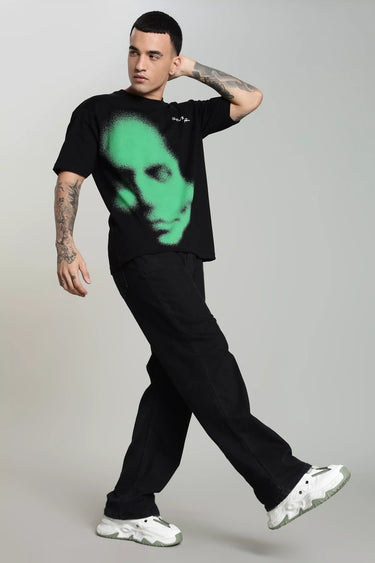 Side profile of a man wearing a green abstract face unisex oversized t-shirt