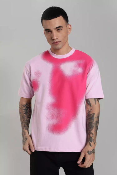 A man wearing a pink oversized abstract face t-shirt