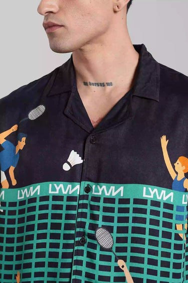 Close-up of a person wearing a navy shirt with tennis themed graphics and text.
