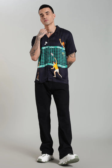 Man wearing a navy tennis themed shirt with graphic design on a gray background