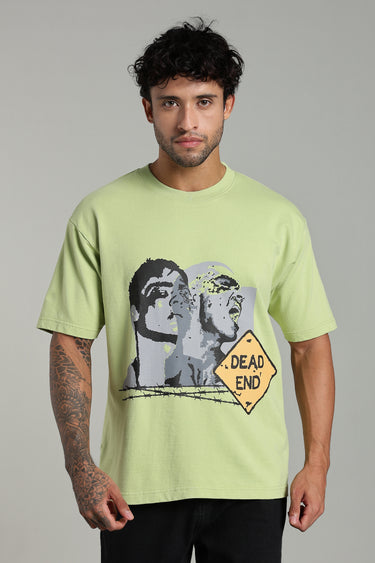 Man wearing the LIGHT GREEN DEAD END OVERSIZED T-SHIRT FOR MEN AND WOMEN with a graphic design on a gray background