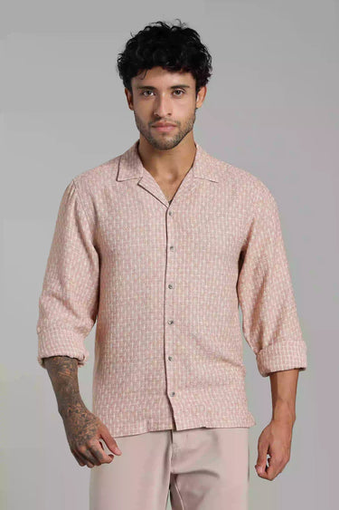 Man wearing a light pink jacquard shirt and pants against a gray background
