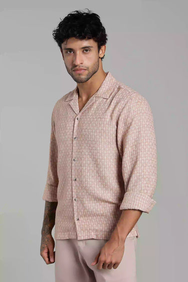 Man wearing a light pink jacquard shirt and pants against a gray background