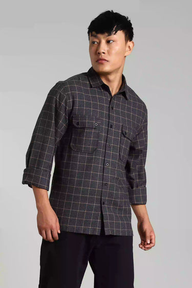 Man wearing a Navy Blue Brushed Yarn Dyed Checked Shacket, a white t-shirt underneath, black pants, and white sneakers on a gray background - sideview