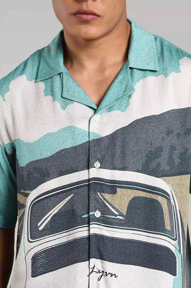 Close-up of a man wearing the BON VOYAGE SHIRT with a vintage car and scenic landscape print, perfect for wanderlust lovers.