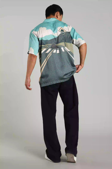 Man wearing BON VOYAGE SHIRT featuring a scenic road trip design, capturing wanderlust and freedom.