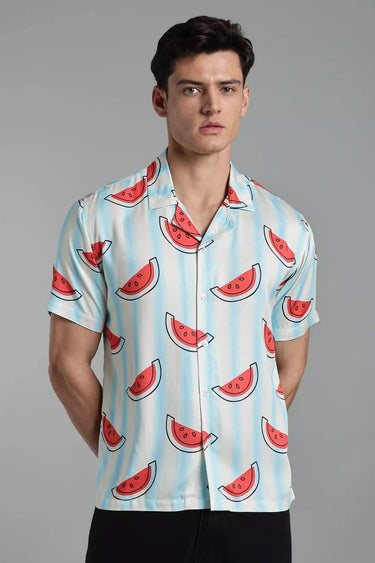 Man wearing a shirt with watermelon pattern against a gray background