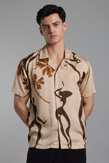 Man wearing a beige boho shirt with brown abstract designs on a gray background