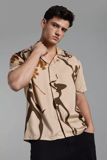 Man wearing a beige boho shirt against a gray background