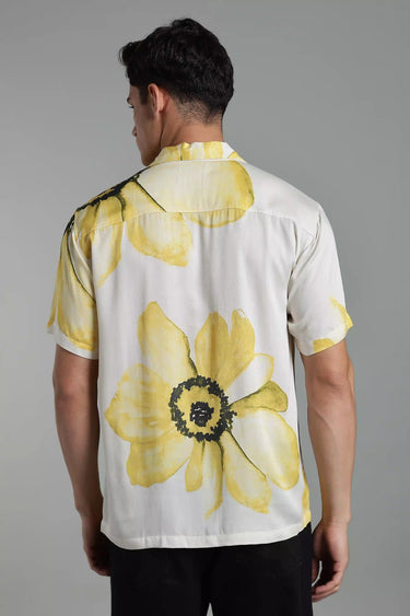 Man wearing a white shirt with yellow floral patterns on a gray background - backview