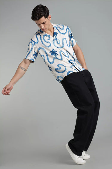 Man wearing a Short-Sleeve Palm Tree Shirt for Men and black pants on a gray background