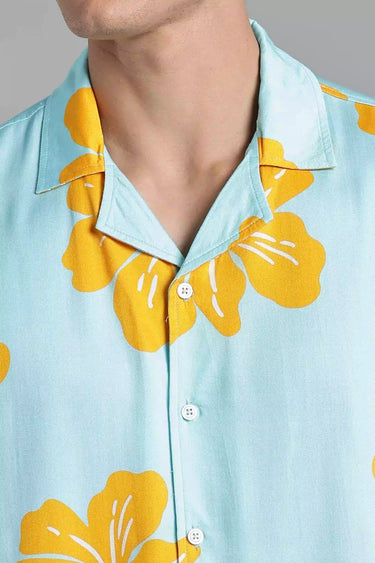 Close up shot of Light blue shirt with yellow floral patterns worn by a person