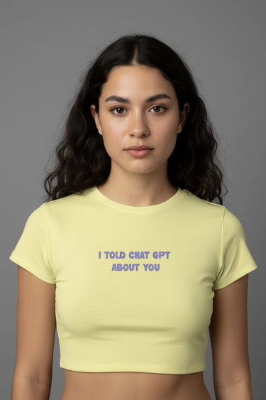 Woman wearing a yellow graphic crop top with text on a gray background