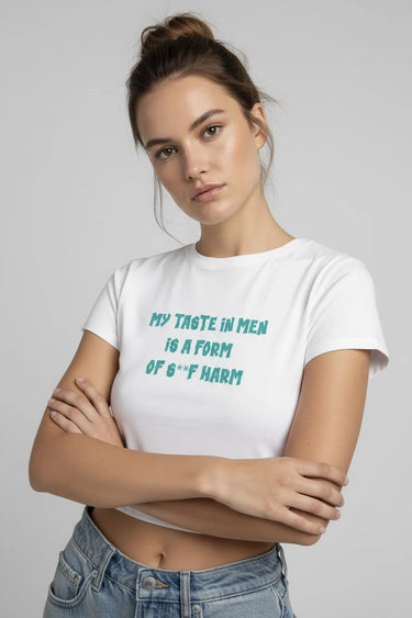 Person wearing a white crop top with text, standing against a plain background