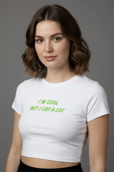 Woman wearing a white crop top with green text on a gray background
