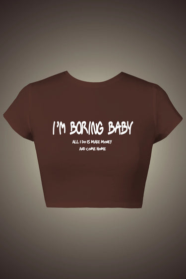 Brown graphic crop top with "I’m Boring Baby" white text and small print detail on front.