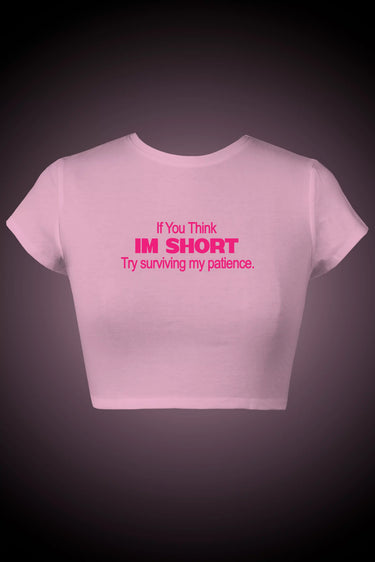 Pink graphic crop top with humorous text on a dark background