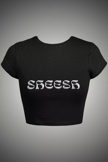 Black crop top with 'SHEESH' text on a gray background