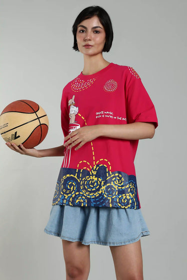 Bright pink graphic oversized t-shirt featuring monster print design and oversized fit paired with a denim skirt. - LYVN