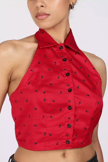 Red halter printed cropped shirt with black button details on a white background - closeup view