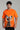 a man wearing orange unisex dog print oversized t shirt 