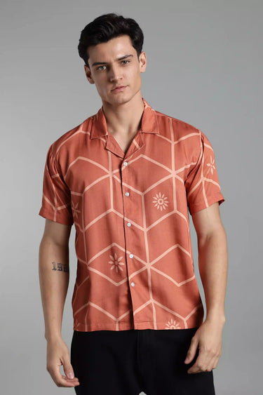 Man wearing a brown tile-patterned shirt against a gray background