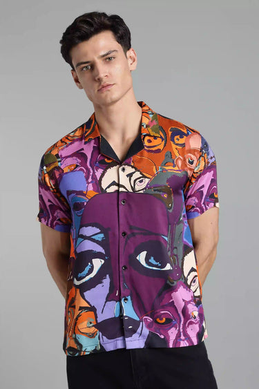 Man wearing a colorful, abstract-patterned shirt on a gray background