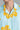 Close up shot of Light blue shirt with yellow floral patterns worn by a person