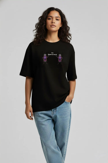 Black oversized graphic t-shirt with colorful floral design worn with light blue jeans.