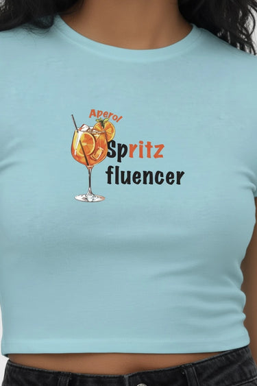 Light blue fitted crop top with orange spritz graphic and text "Aperol Spritz fluencer" on front.