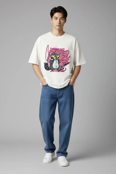 Person wearing a white unisex oversized t-shirt with a graphic design and blue jeans on a gray background