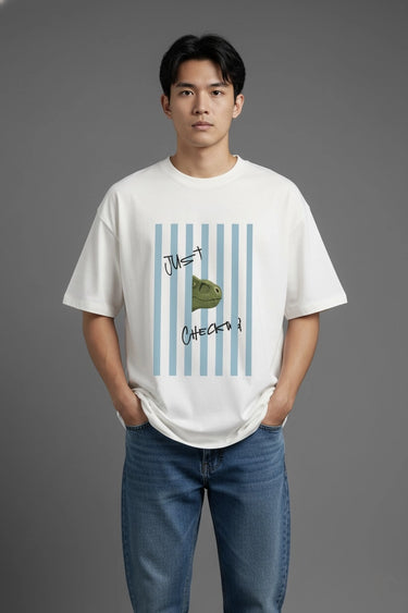 Person wearing a half white unisex oversized  t-shirt with a graphic design on a gray background