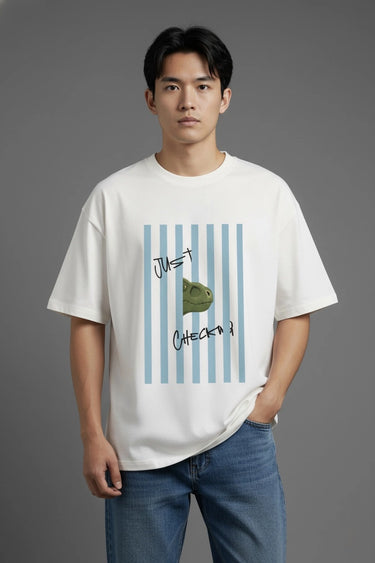 Person wearing a half white unisex oversized  t-shirt with a graphic design on a gray background