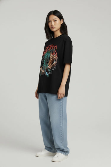 Black oversized graphic t-shirt with colorful tiger and red lettering, paired with loose light blue jeans.
