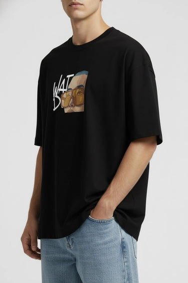 Black oversized graphic t-shirt with abstract brown and white design, worn with light blue jeans.