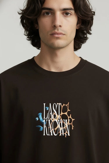 Black oversized graphic t-shirt with cracked text design reading Last Known on front.
