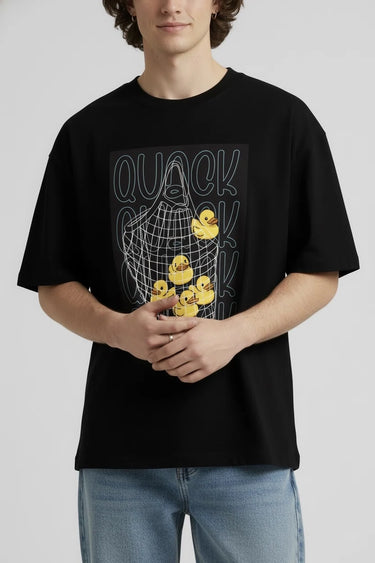 a person posing with a black oversized graphic t-shirt with a duck doll. 