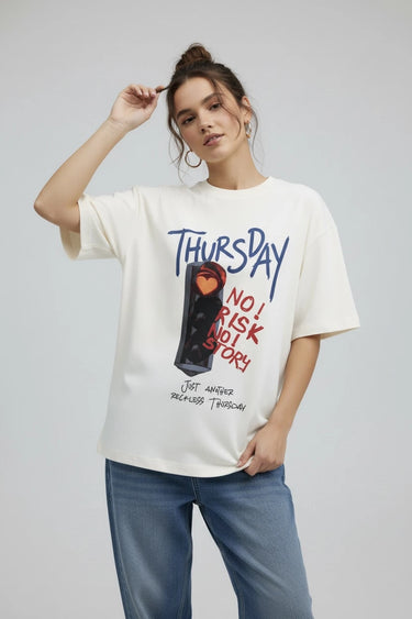 A woman wearing the Thursday half white oversized graphic t-shirt 