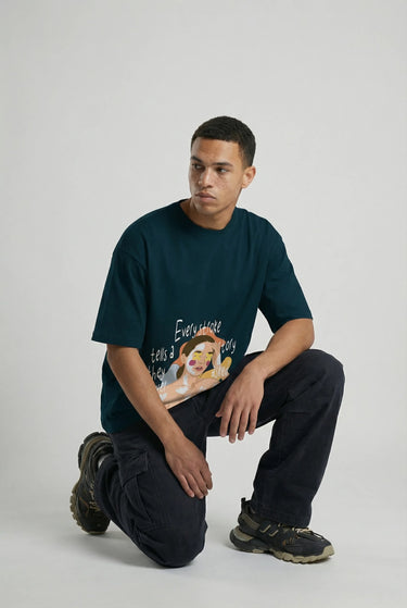 Navy oversized graphic t-shirt with colorful cartoon print, worn with black pants and sneakers.