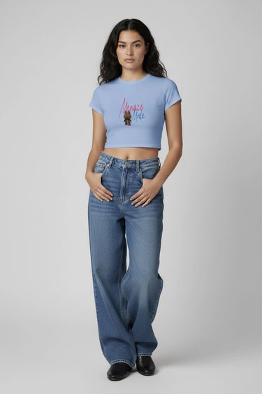 Light blue graphic crop top with colorful monster print and short sleeves worn with wide-leg jeans. - LYVN