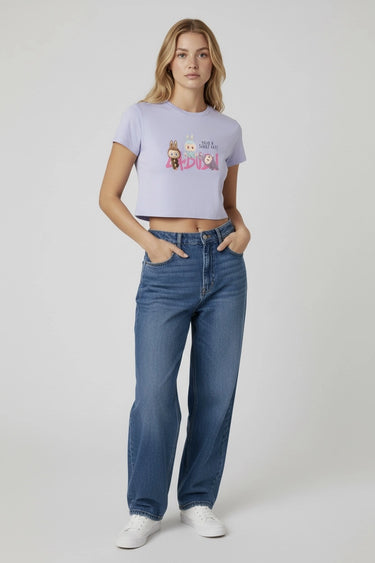 Lavender graphic crop top with colorful monster print worn with blue jeans and white sneakers. - LYVN