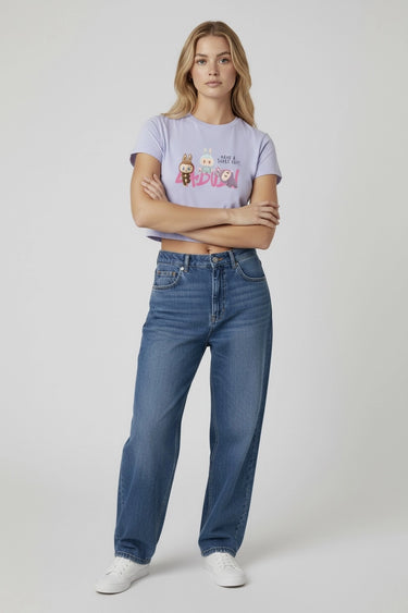 Light purple graphic crop top with colorful monster print worn with high-waisted blue jeans. - LYVN