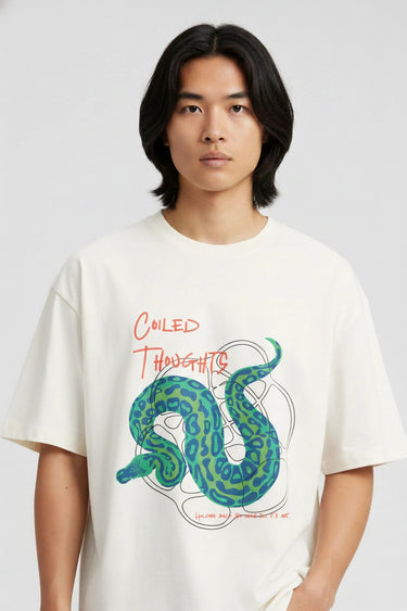 Cream oversized graphic T-shirt with green coiled snake and red "Coiled Thoughts" text on front.