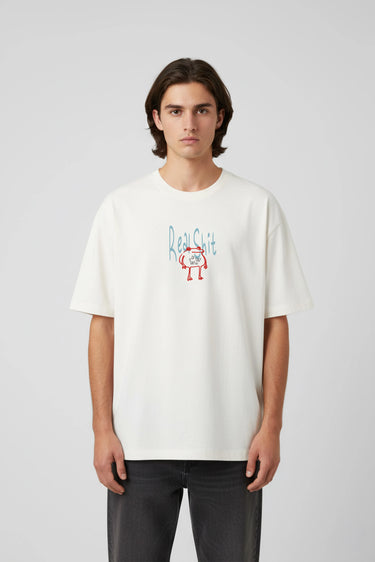 White oversized graphic t-shirt with small colorful "Real Shit" text and design on front.